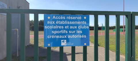 Le panneau boulonné sur le portail : accès réservé aux établissements scolaires et aux clubs sportifs sur les créneaux autorisés — Stade Patrick Perrais, Bouaye