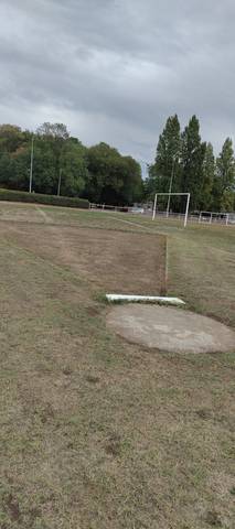 Le butoir blanc du cercle de poids, et l'aire de chute en terre sèche — Complexe Sportif de la Croix Jeannette, Bouguenais