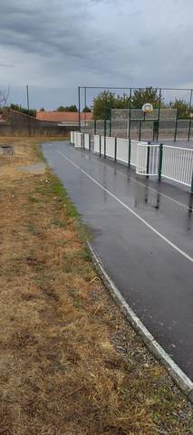 L'anneau le long du terrain multisport : la bordure béton du city-stade et sa barrière métallique empiètent sur le couloir 1 — Stade Municipal des Chataigniers, Saint-Hilaire-de-Chaléons