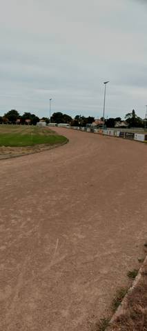 L'anneau en cendrée en sortie de virage, sans aucune ligne de couloir, bordure béton côté extérieur — Complexe Sportif du Parc du Grand Fay, Saint-Père-en-Retz