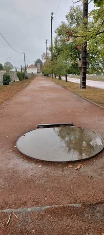 L'aire de lancer du poids : cercle béton avec son butoir, entièrement noyé sous une flaque, au bord de la cendrée gorgée d'eau — Complexe Vertou Centre, Vertou