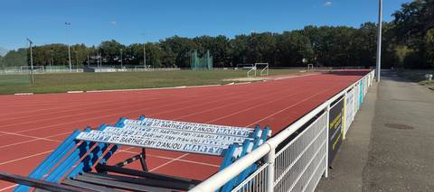 L'anneau en tartan, des haies stockées au bord de la piste, et le sautoir en arrière-plan à gauche — Complexe Sportif de la Venaiserie, Saint-Barthélemy-d'Anjou