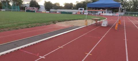 Le sautoir de longueur et son bac de sable au bord de la piste ; la tente des juges, montée pour la compétition du jour — Complexe sportif Jean Léveillé, Challans