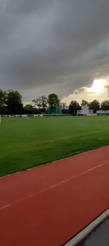 La pelouse centrale depuis la piste ; au fond, la cage de lancer et les buts de football — Complexe sportif Jean Léveillé, Challans