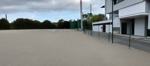 La cage de lancer, grillage vert sur mâts courbes et vantaux relevés, au bord de l'aire stabilisée que le recensement déclare aussi pour les lancers — Complexe sportif Jean Léveillé, Challans